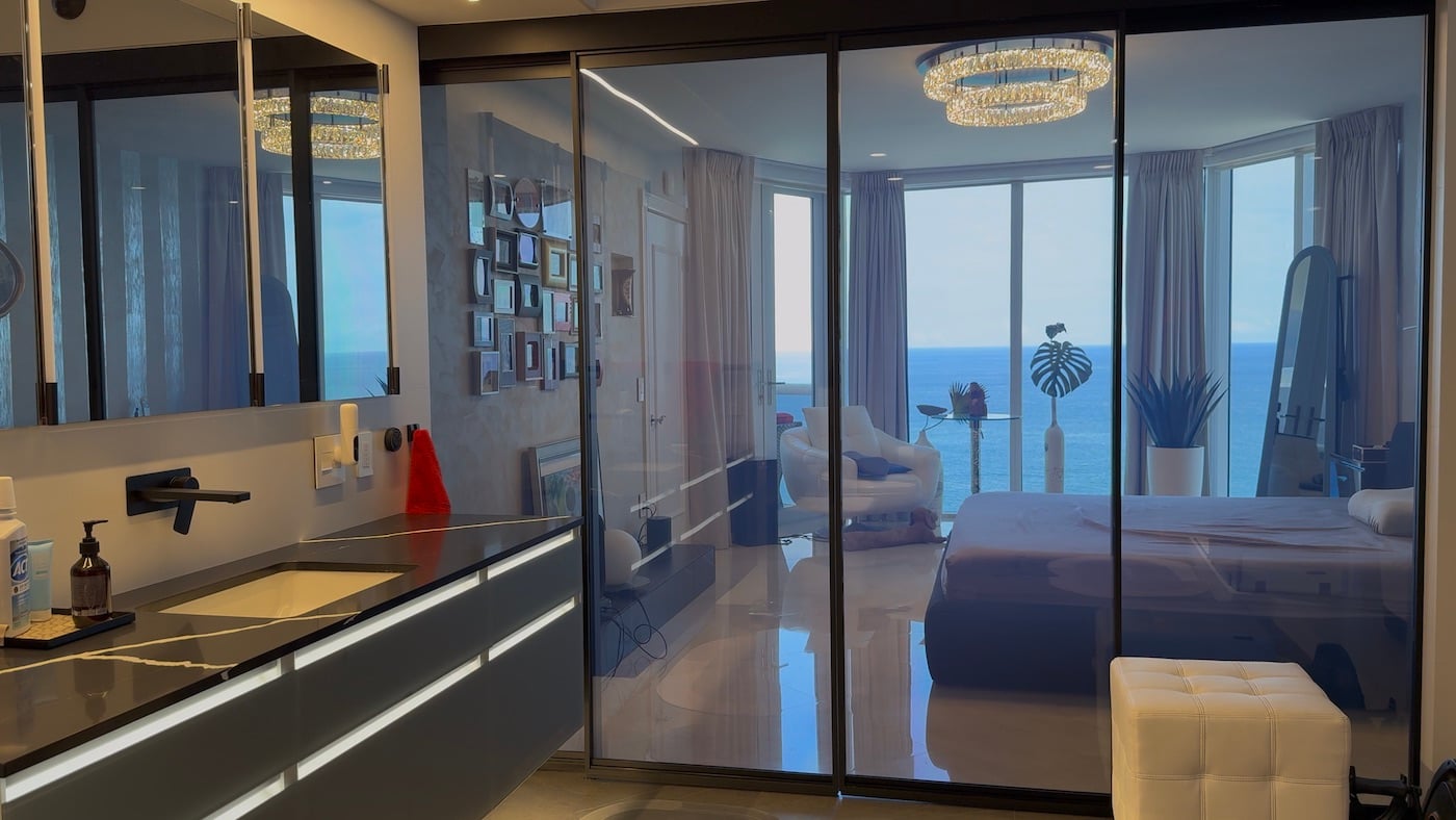 Suite residencial con división de vidrio transparente antes de activar Smart Glass